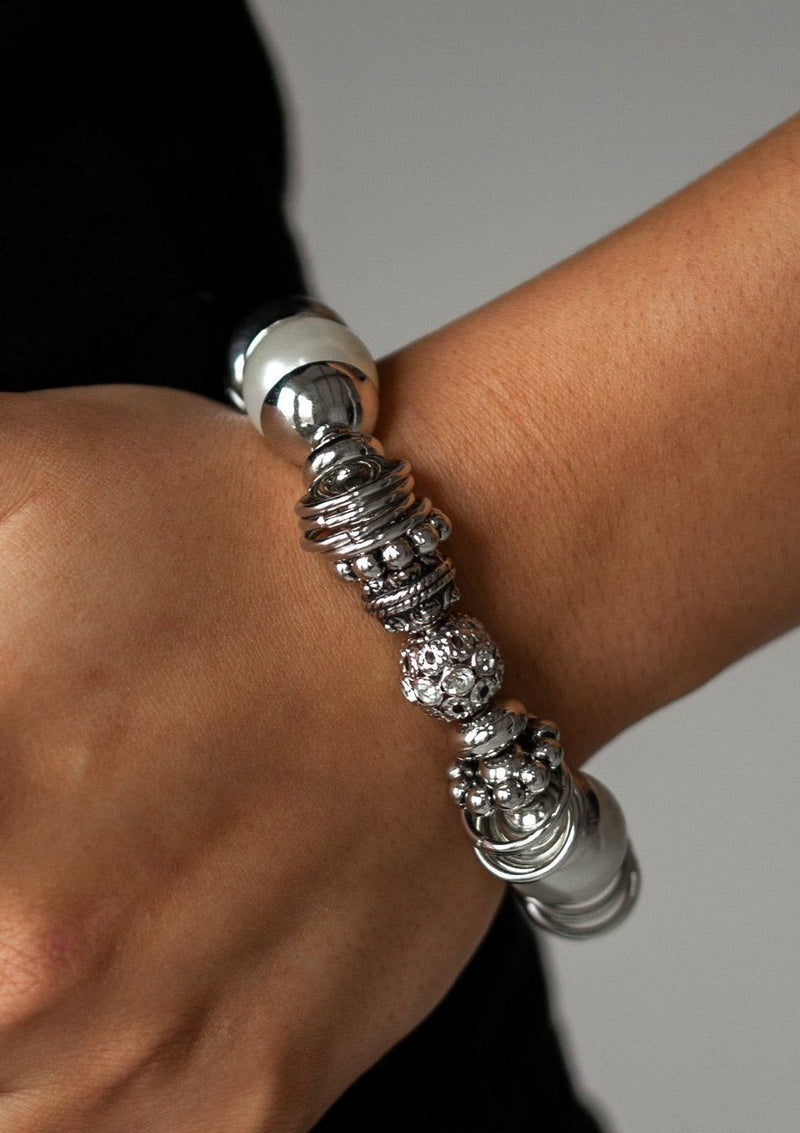 Uptown Tease - Paparazzi - Silver Stretch Bracelet - Popping Pearls A collection of oversized white pearls, mismatched silver accents, and white rhinestone encrusted beads are threaded along a stretchy band around the wrist for a show-stopping look.  Free shipping on orders over $50